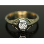 A diamond solitaire ring, hexagonal bezel above open work setting and shoulders, band marked '18ct',