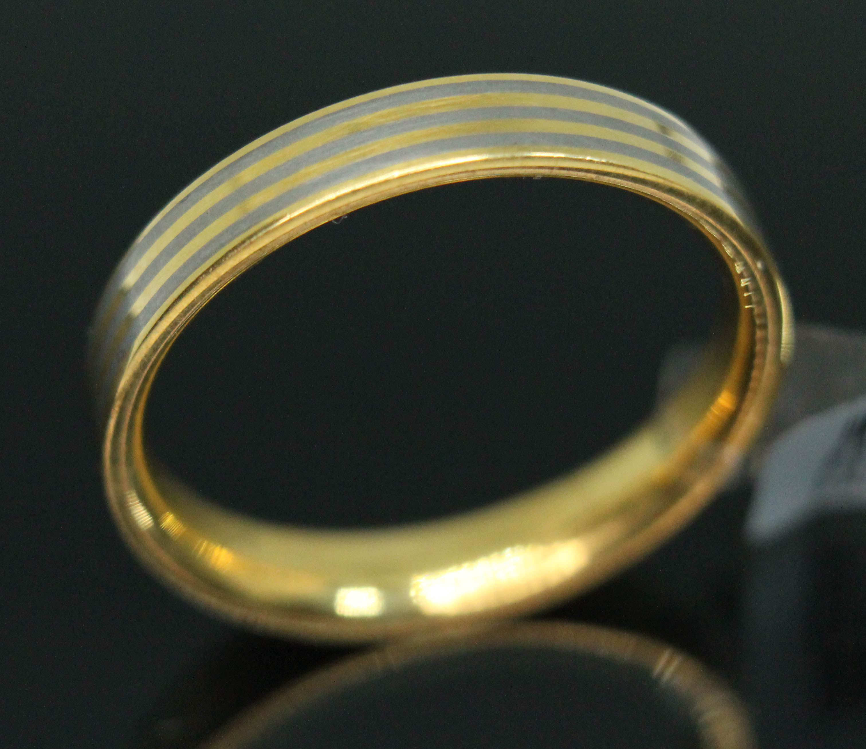 A yellow metal and titanium wedding band by Feniom, inverted D-section with alternate bands to outer