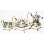 A George VI three piece silver tea set, the tea and coffee pots with ivory handles and finials, each