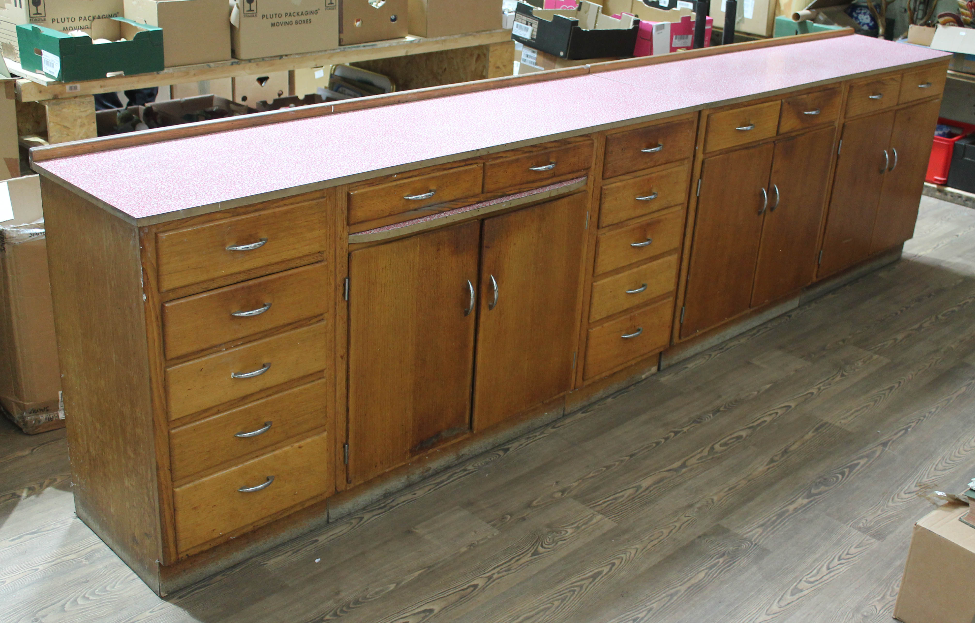 A pair of 1950s light oak kitchen units, patterned melamine tops, one with pull out slide and