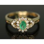 A hallmarked 18ct gold diamond and emerald cluster ring, the cluster measuring approx. 13.05mm x 8.