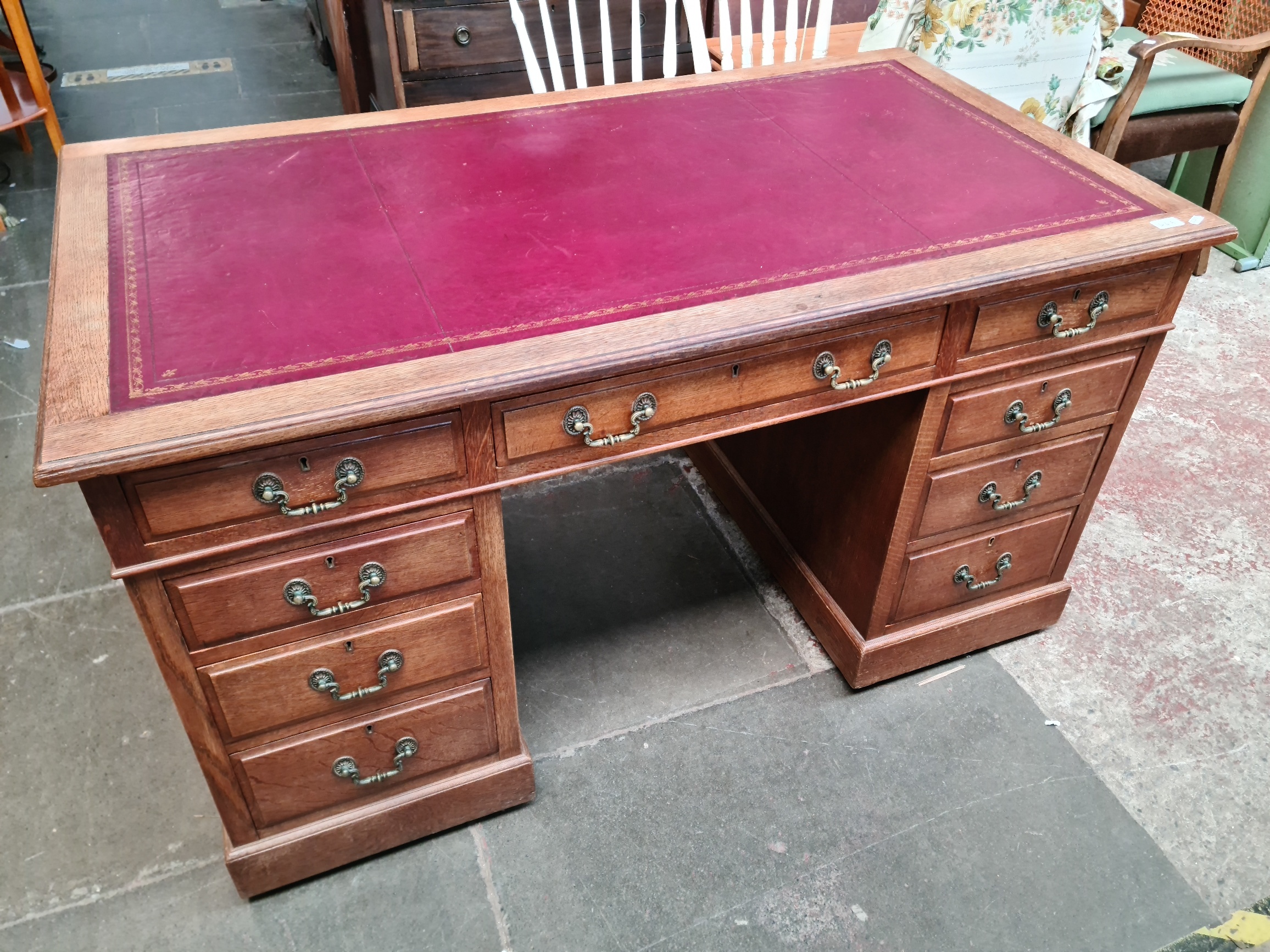 An oak pedestal desk circa 1900 with red leather top