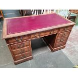 An oak pedestal desk circa 1900 with red leather top