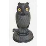 A 19th century Irish bog oak inkwell modelled as an owl, detachable head with glass eyes, sat on