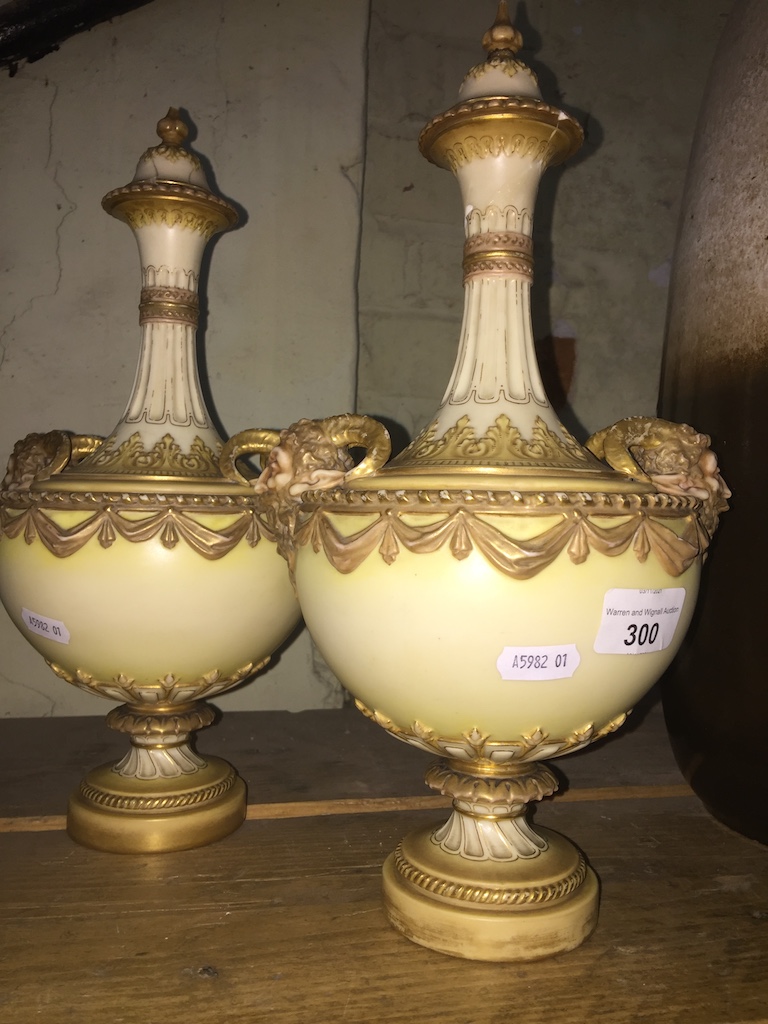A pair of Royal Worcester blush ivory lidded vases.