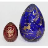 Two etched glass eggs, the red egg with Faberge sticker to base, the blue egg unmarked, heights 7.