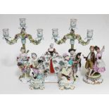 A group of continental porcelain comprising a pair of candelabra, two figures bearing gold anchor