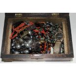 A wooden box of costume jewellery.