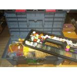A tool box containing a collection of fly tying materials including threads, feathers, dubbing and