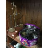 An old weighing scale with bottom drawer and a tin with various weights.