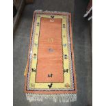 A vintage Turkish orange ground carpet, 131cm x 63cm.