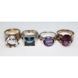 A group of four contemporary crafts rings comprising one hallmarked silver set with a round mixed