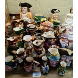 A quantity of toby jugs including a 19th century Staffordshire toby jug and other modern jugs.