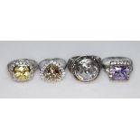 A group of four halo design rings, all marked '925', sizes O,P & U.