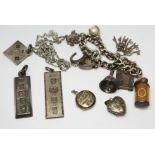 Assorted silver jewellery comprising three ingots, a charm bracelet and a locket, gross weight 133.
