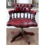 An oxblood red leather swivel chair.