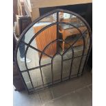 A metal framed arched mirror.