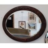 Early 20th century oval oak framed mirror, 73cm x 56cm.