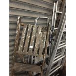 A pair of aluminum step ladders, a set of wooden stepladders and 3 way ladder.