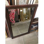 A wooden frame mirror, ebonised and gilt decoration on inner edge.
