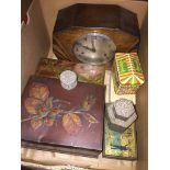 A box of old tins and a mantel clock.