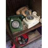 A group of three vintage telephones.