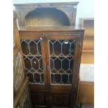 An Old Charm oak and leaded glass cabinet and an oak cabinet bookcase.
