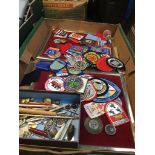A box containing various badges, medals and collectables