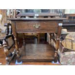 An aged oak side table with drawer.