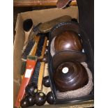 A box containing carpet bowls, brushes and a set of wooden crown green bowls in case.