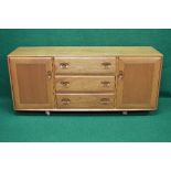 Blonde Ercol sideboard having three central drawers flanked by cupboard doors,