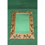 Carved wood gilt painted wall mirror having rectangular bevelled glass in a scrolled carved frame -