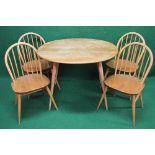 Blonde Ercol oval kitchen/dining table having solid top supported on outward splayed turned