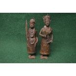Pair of bronze Benin statues of female tribal figures holding weapons and implements,