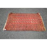 Red ground rug having black and cream pattern with end tassels - 54" x 34"