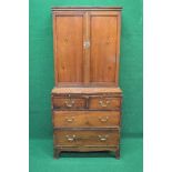 19th century yew wood cupboard on chest the top having two panelled doors opening to reveal two