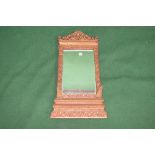 Possibly Siamese carved wall mirror having rectangular bevelled glass surmounted by a carved