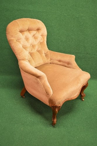 Victorian buttoned spoon back ladies armchair having pale gold upholstery and shaped seat front,