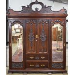 Good quality mahogany triple wardrobe having moulded cornice over two central carved panelled doors