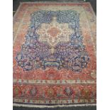 Large blue and red ground carpet having floral pattern of reds, blues,