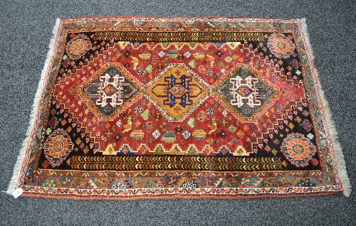 Red ground rug having blue, green and gold pattern with end tassels - 45.