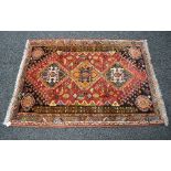 Red ground rug having blue, green and gold pattern with end tassels - 45.