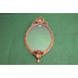 Oval gilt framed wall mirror having applied decoration and bearing a label on verso for C Nosotti,