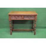 20th century oak two drawer side table the top having moulded edge over carved drawers with turned