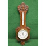 Oak Aneroid wall barometer having carved decoration surmounting thermometer,