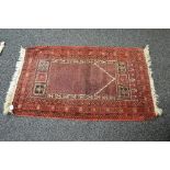 Red ground rug having a black and white pattern with end tassels - 35" x 61"