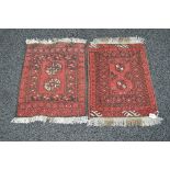 Two small red ground rugs having black and cream pattern with end tassels - 20" x 29" approx each