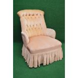 Victorian button back armchair having overstuffed seat and standing on turned legs ending in