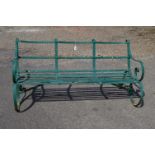 Victorian iron garden bench having scrolled arms over metal slatted seat,