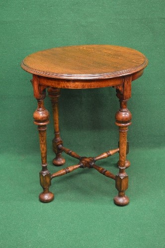 Circular oak occasional table the top having moulded edge supported on four turned legs with lower